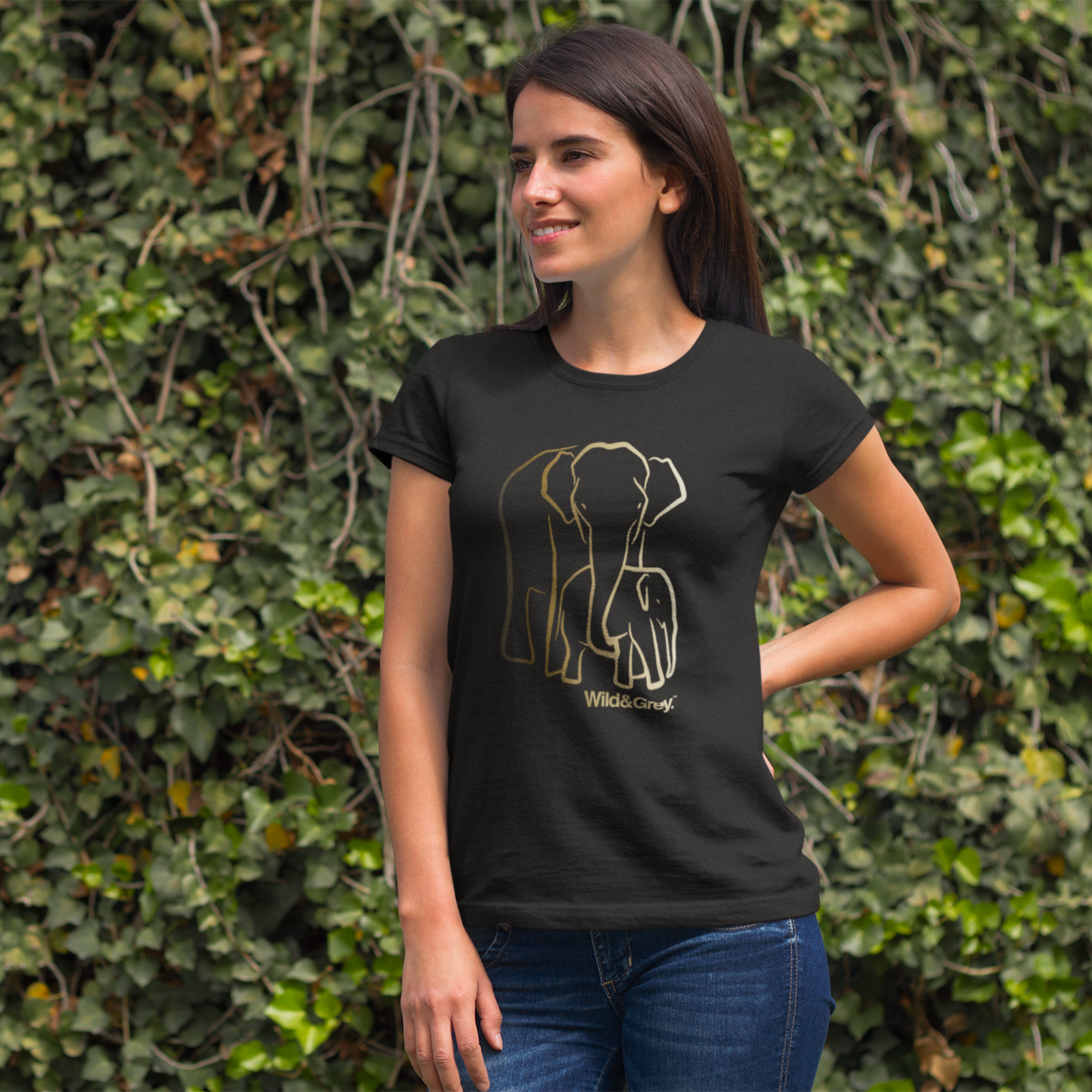 Woman wearing a black t-shirt with an elephant design in front of a green leafy background