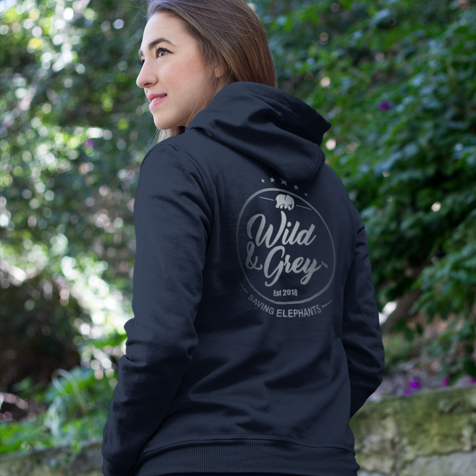 Person wearing a black hoodie with 'Wild & Grey' logo outdoors