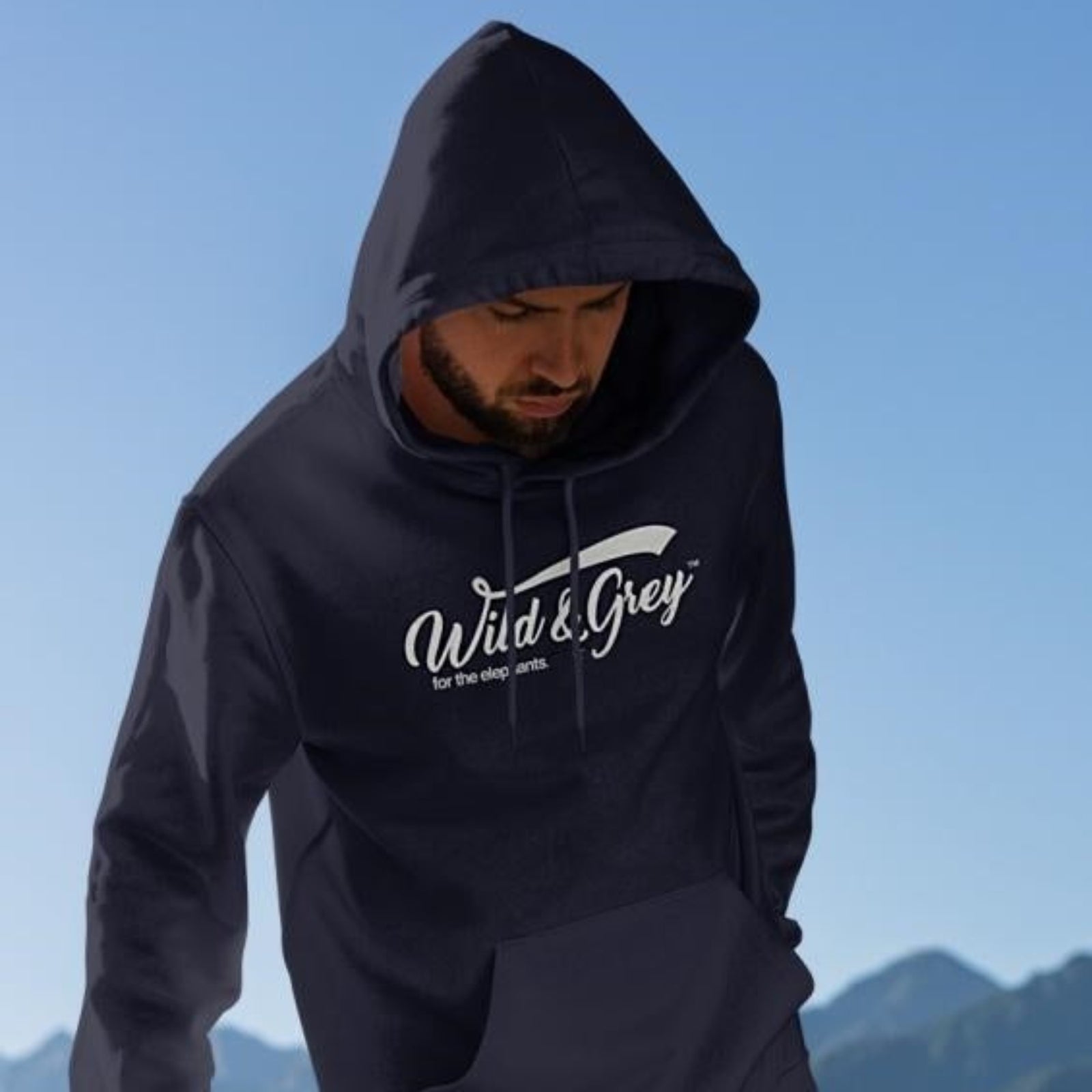 A man wearing a navy blue hoodie with the text 'Wild&Grey' and an elephant graphic on the front.